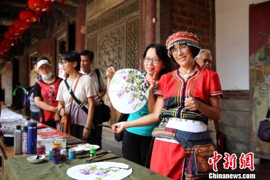 台湾画家高春英现场画小品，赠与前来观展的民众，为图片展助兴。　黄少华 摄